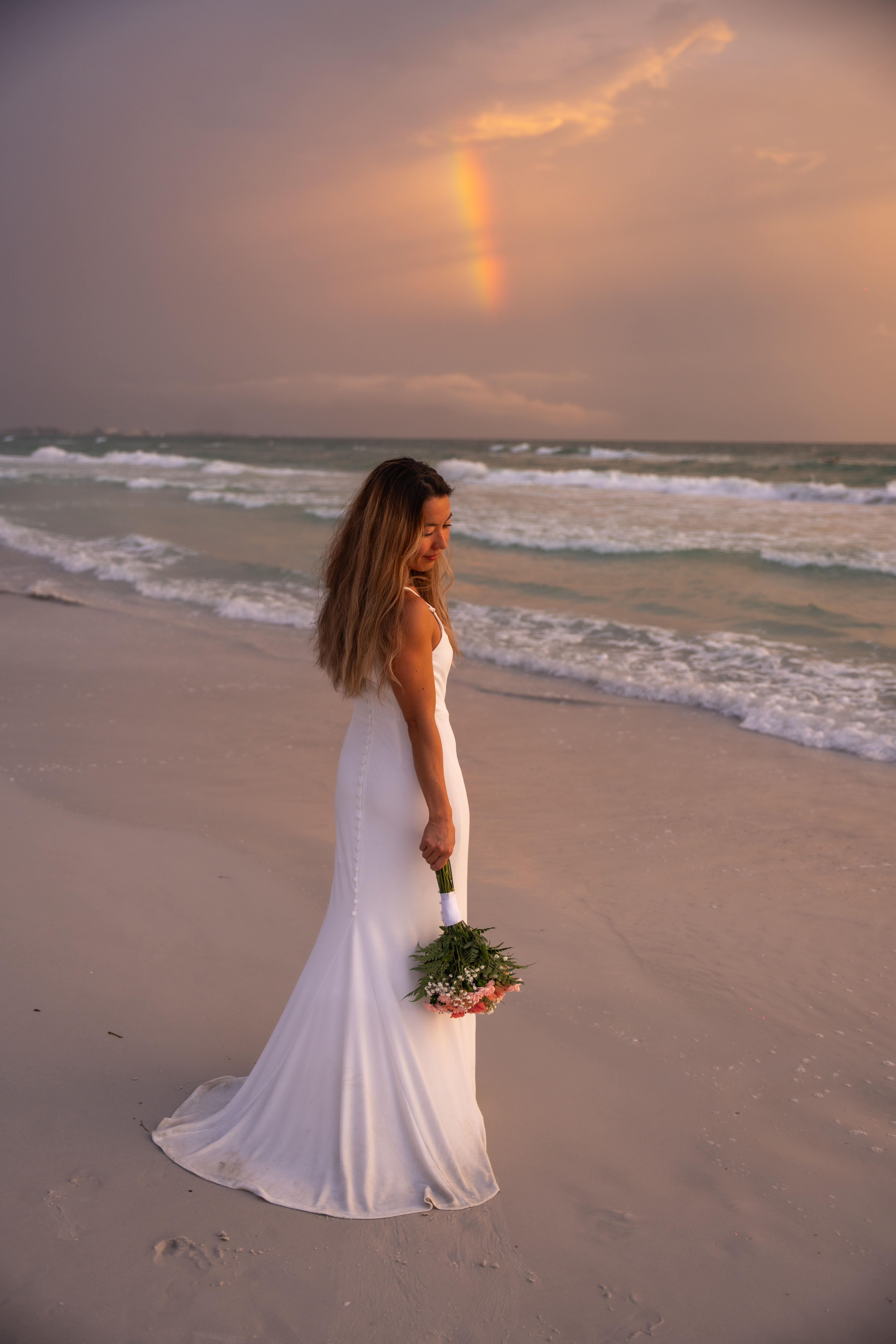 Wedding couple silhouetted against the sunset on the beach