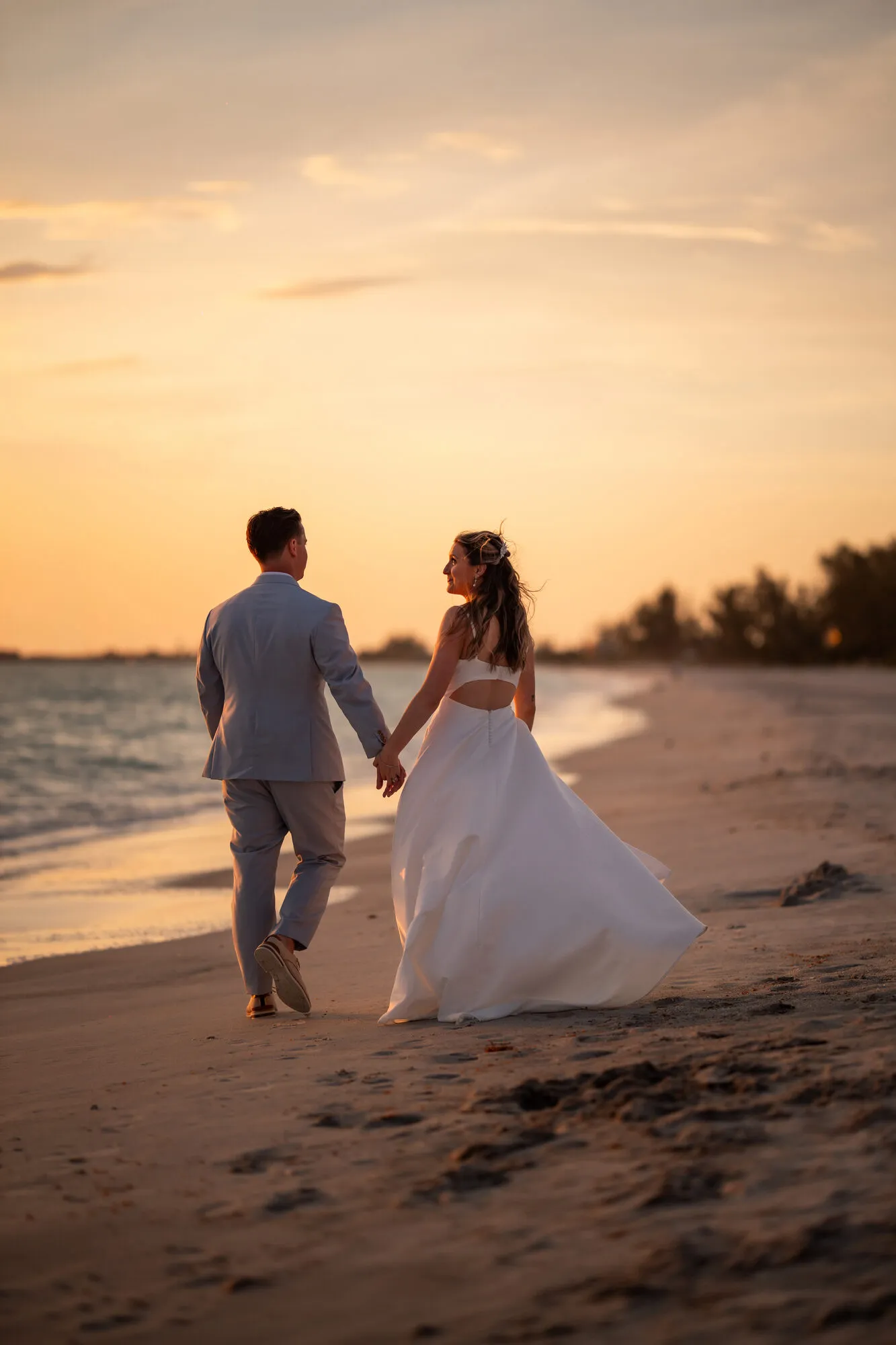 Couple walking hand in hand through tropical gardens after the ceremony